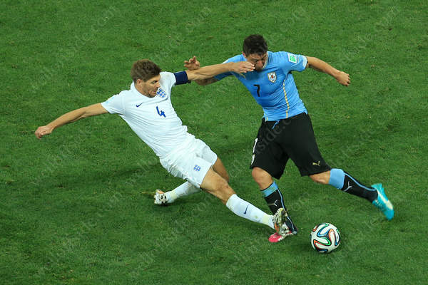 Steven Gerrard of England tackles Uruguay's Christian Rodriguez